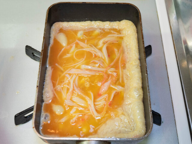 卵焼き器に卵液を流し入れた写真