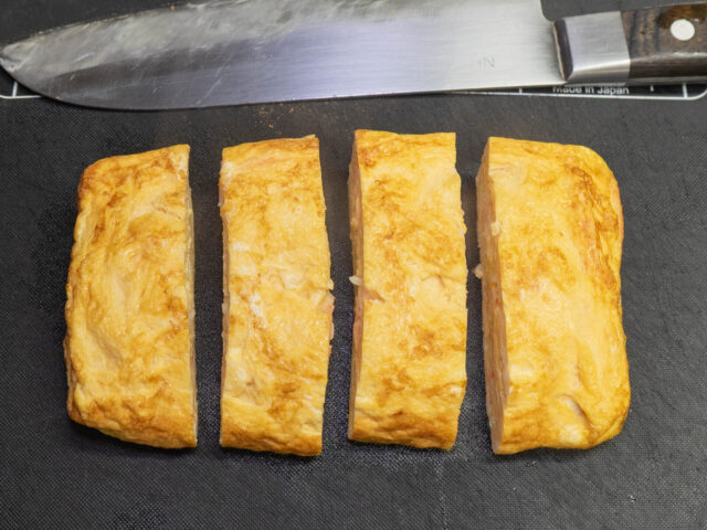 だし巻き卵を包丁で切り分けた写真