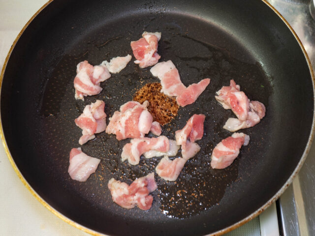 フライパンにサラダ油を熱して、豚肉を入れた写真