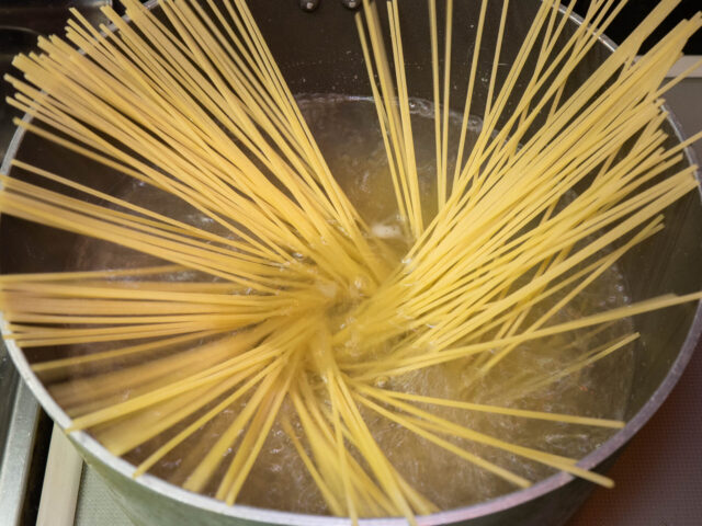 鍋にお湯を沸かし、塩を適量溶かしてからパスタを入れた写真