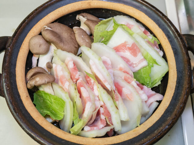 鍋に白菜ではさんだ豚肉と平茸、水を入れた写真