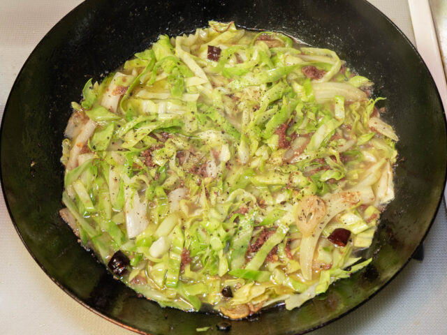 パスタの茹で汁を加え、胡椒を挽いた写真