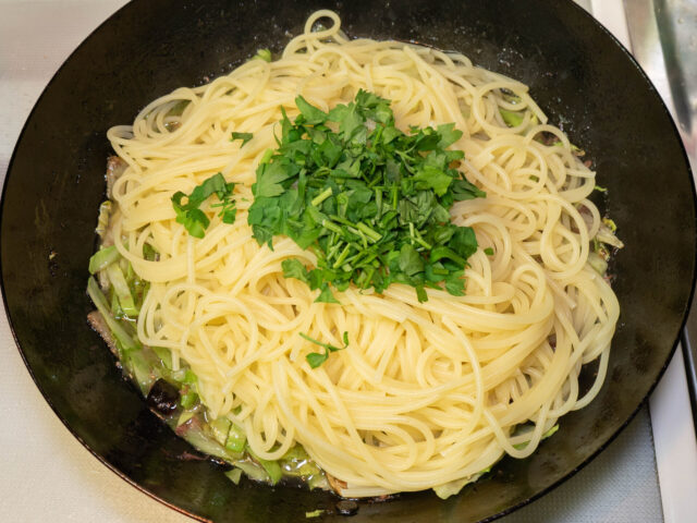 パスタとパセリをソースのフライパンにあわせた写真