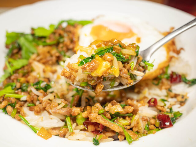 卵の黄身をつけたパクチーライスをスプーンにのせた写真
