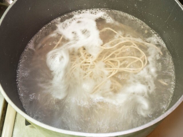 鍋にお湯を沸かし、蕎麦を茹でる写真