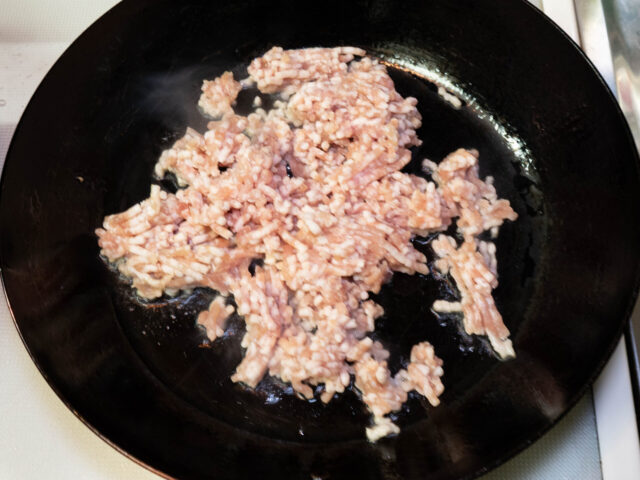 フライパンにサラダ油を熱して、ひき肉を加えた写真