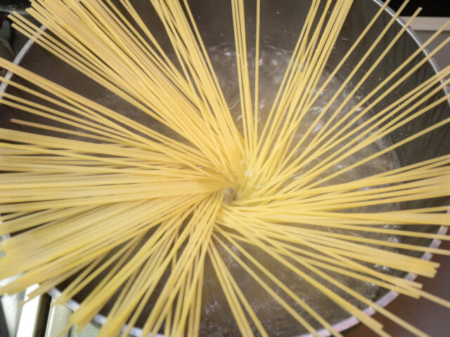 鍋にお湯を沸かし、塩を適量溶かしてからパスタ加えた写真