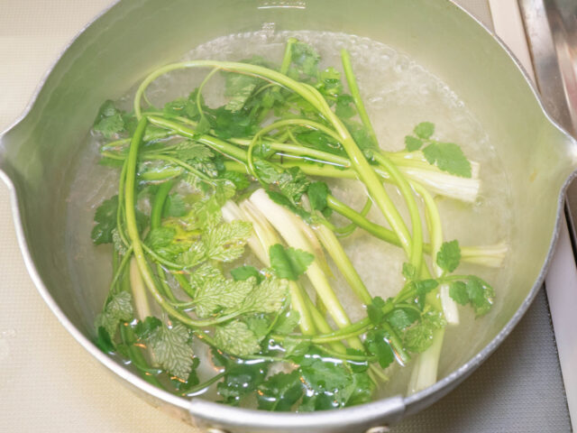 鍋にお湯を沸かし、芹を加えた写真