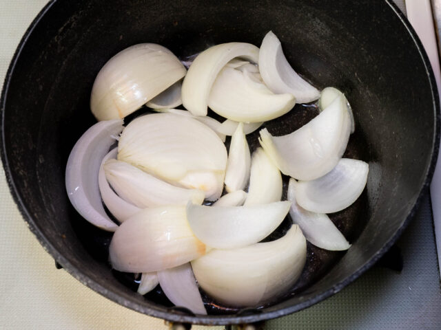 鍋にサラダ油を熱してタマネギを入れた写真