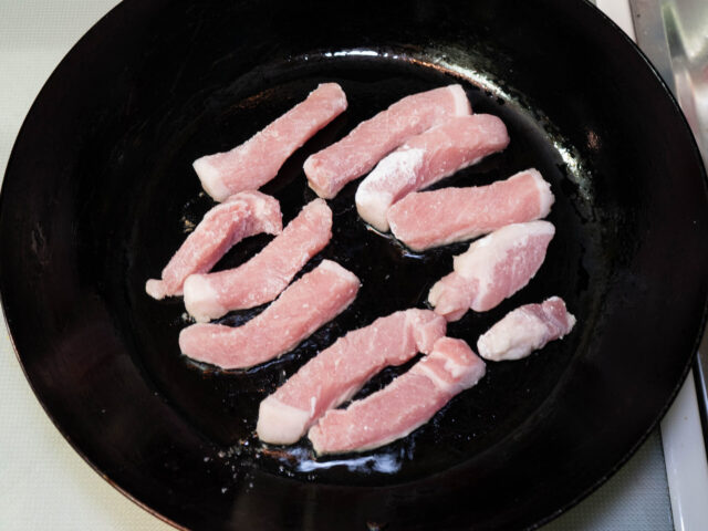 フライパンにサラダ油を熱して、豚肉を並べ入れた写真