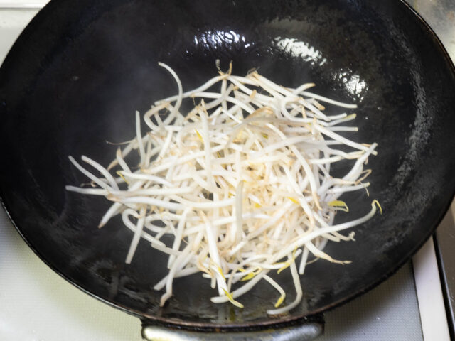 中華鍋にサラダ油を熱して、もやしを加えた写真