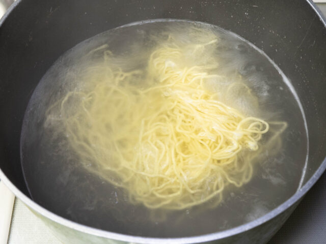 鍋にお湯を沸かし、麺を茹でる写真
