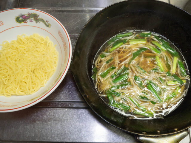 丼に入れた麺と、中華鍋でつくったスープの写真