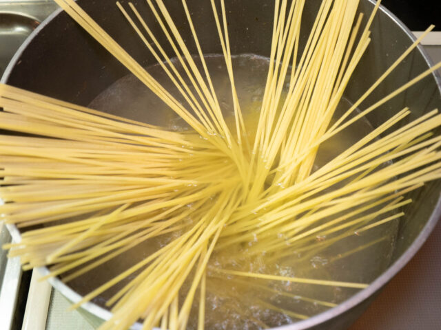 鍋にお湯を沸かしてパスタを入れた写真