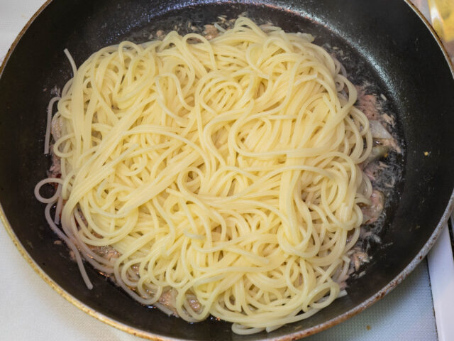ソースのフライパンに、茹で上がったパスタを加えた写真
