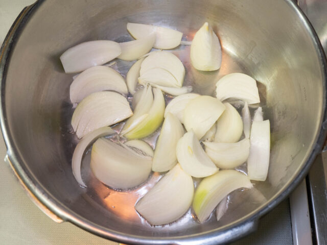 圧力鍋にサラダ油を熱して、玉ねぎを入れた写真