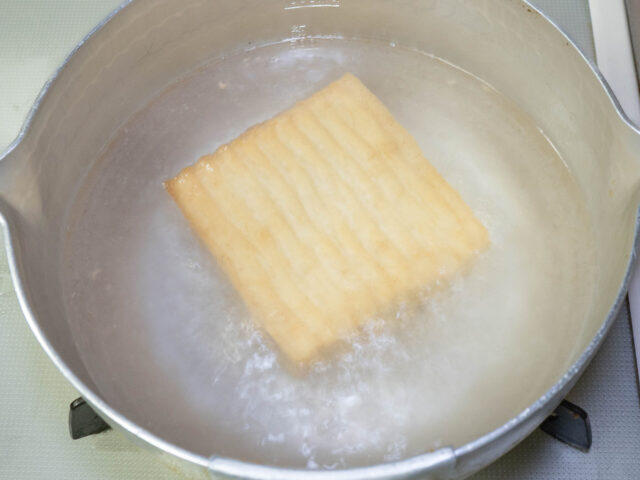 鍋にお湯を沸かし、厚揚げを湯通しする写真