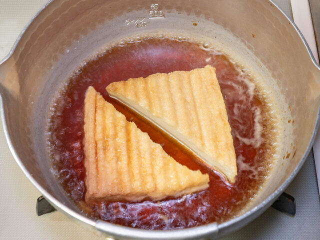 鍋に調味料と厚揚げを入れて煮る写真