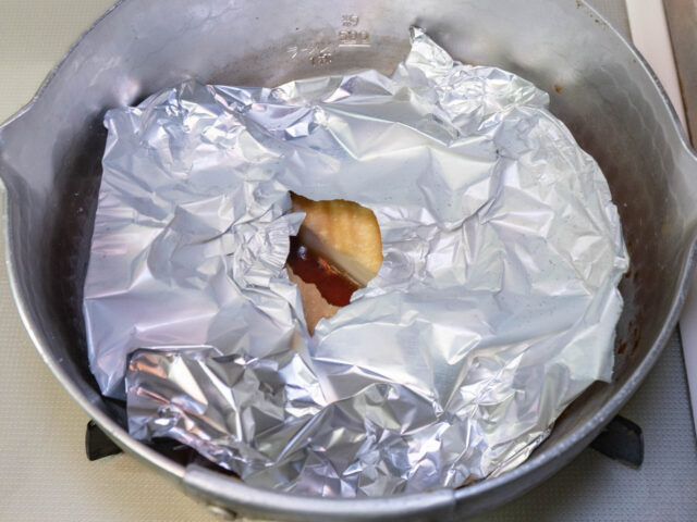 アルミホイルの落とし蓋をして煮る写真