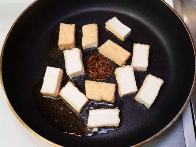 フライパンにごま油を熱して厚揚げを並べ入れた写真