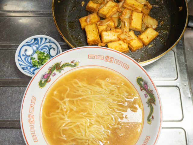 丼に入れたラーメンと、フライパンの炒めものの写真