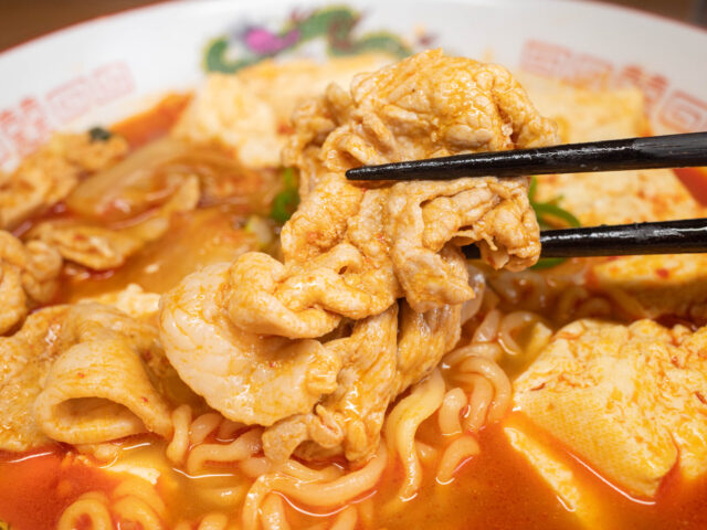 豚肉を箸で持ち上げた写真