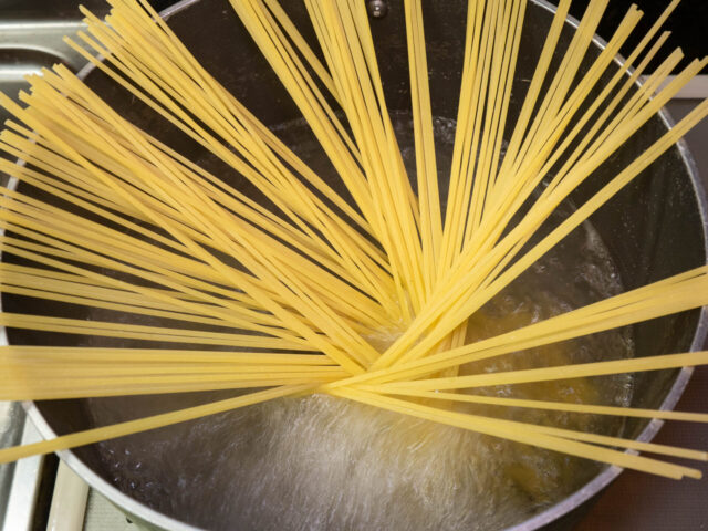 鍋にお湯を沸かし、塩を適量溶かしてからパスタを入れた写真