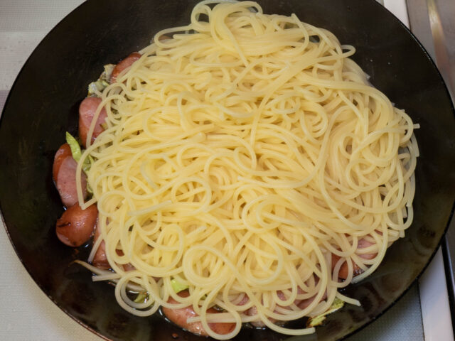ソースのフライパンに、茹で上がったパスタを合わせた写真