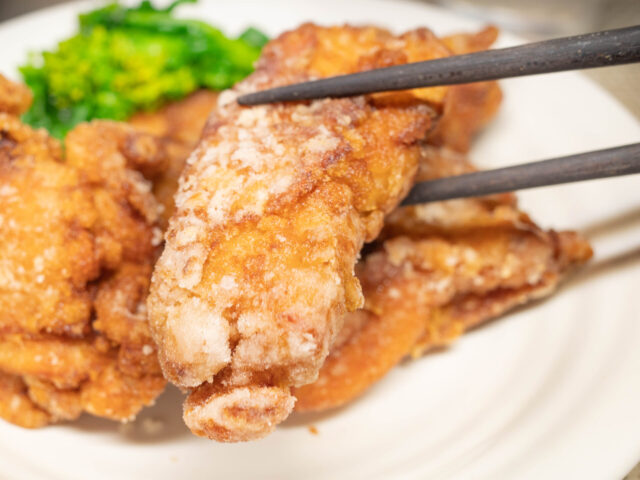竜田揚げを箸で持ち上げた写真