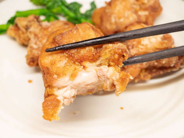 竜田揚げを箸で持ち上げた写真