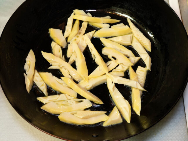 フライパンにオリーブオイルを熱してタケノコを入れた写真