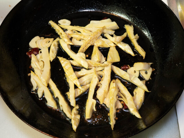 炒めたタケノコをフライパンに戻した写真