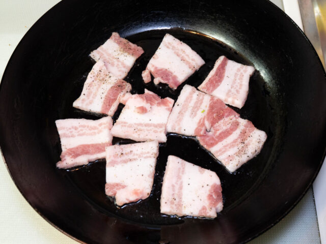 フライパンにサラダ油を熱して、豚バラ肉を並べた写真