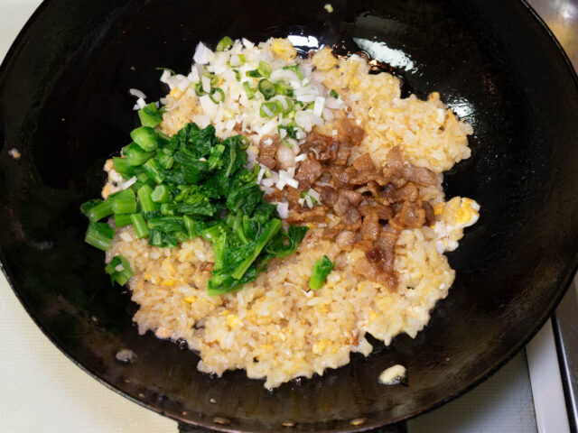 取り出しておいた豚バラ、下茹でして刻んだ菜の花、長ねぎを加えた写真