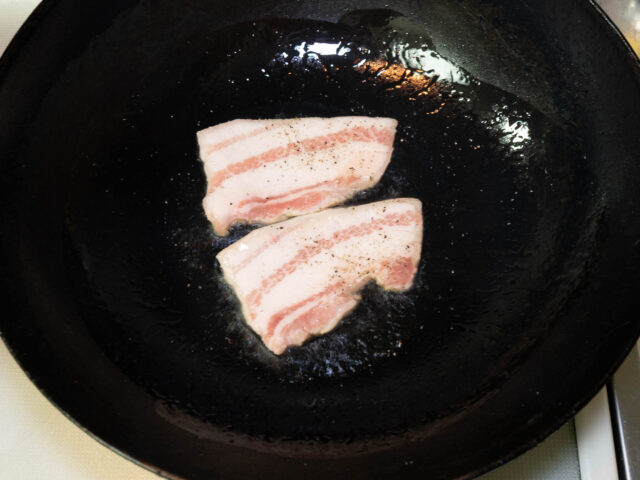 中華鍋にサラダ油を熱して、豚バラ肉を加えた写真