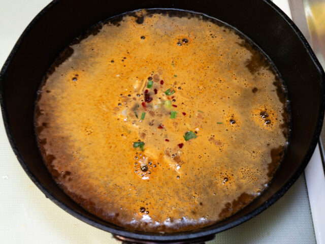 鍋にお湯を沸かし、粉末スープとかやくを加えた写真