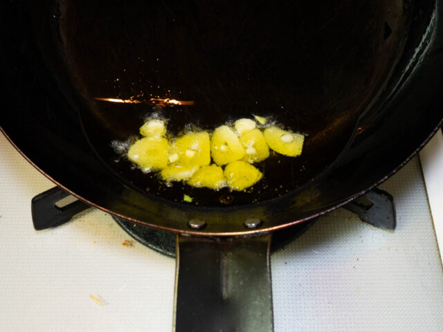 フライパンにオリーブオイル、ニンニクを入れて弱火で加熱する写真