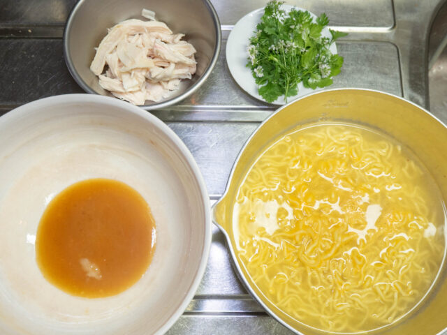麺を茹でた鍋、液体スープを入れた丼、ほぐした茹で鶏、パクチーの写真