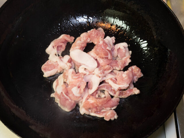 中華鍋にサラダ油を熱して、豚肉を加えた写真