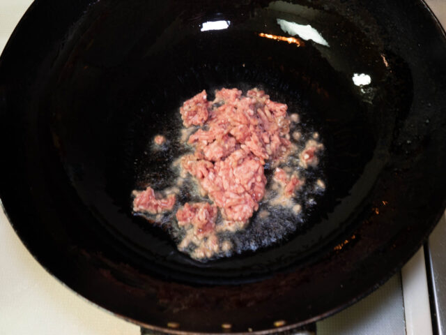 中華鍋にサラダ油を熱して、ひき肉を炒める写真