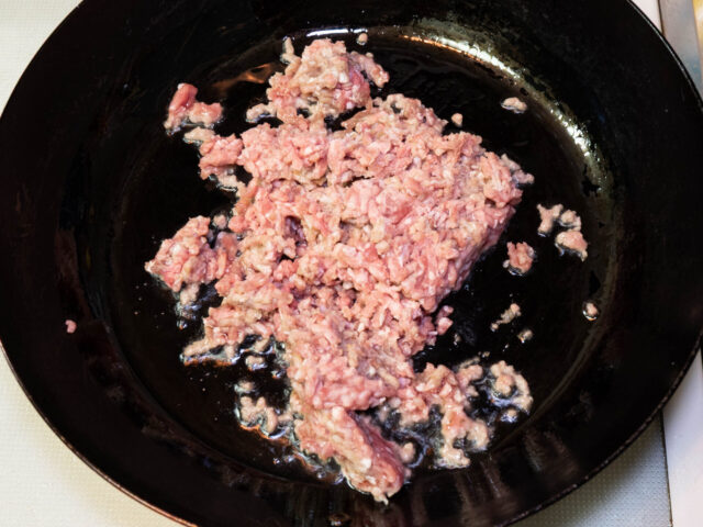 フライパンにサラダ油を熱して、ひき肉を加えた写真