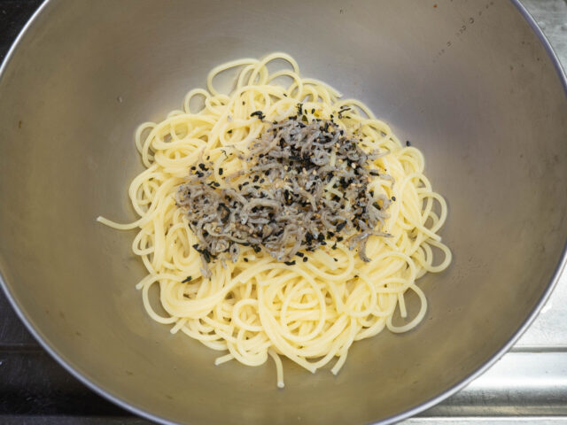 ボウルに茹で上がったパスタ、オリーブオイル、パスタの茹で汁、しそちりめんを加えた写真
