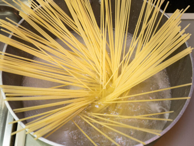 鍋にお湯を沸かし、塩を適量溶かしてからパスタ加えた写真