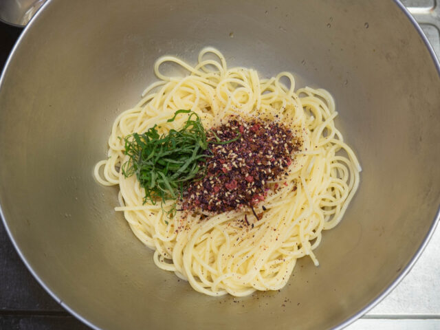 ボウルに茹でたパスタ、ふりかけ、シソを加えた写真